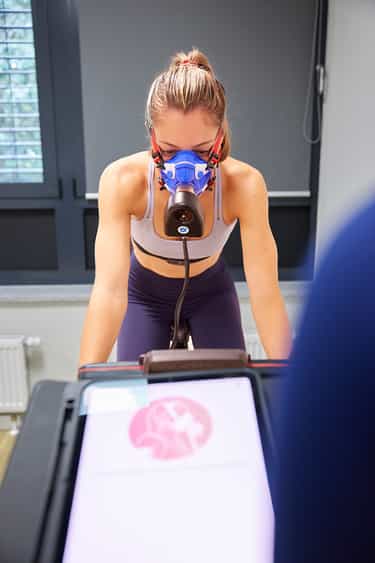 Sportlerin mit Atemmaske während des Stufentests