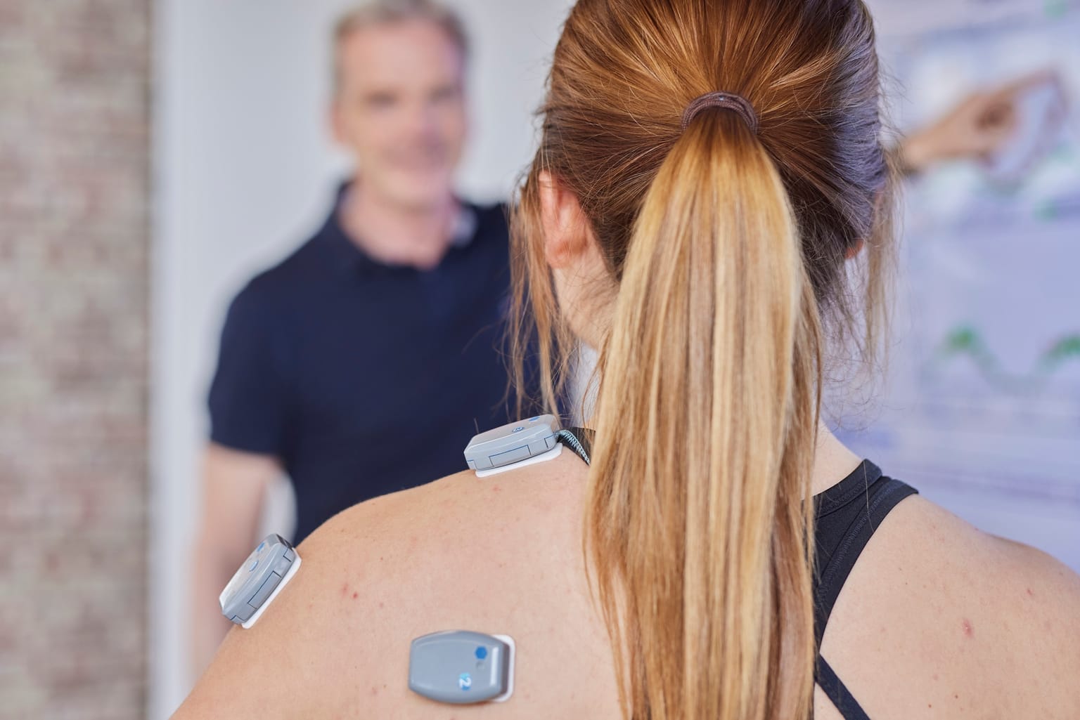 Drahtlose EMG-Sensoren auf der Schulter- und Nackenmuskulatur einer Patientin